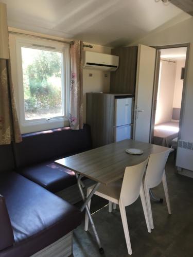 une salle à manger avec une table et des chaises et une cuisine dans l'établissement PROCHE du PONT GENOIS, à Sartène