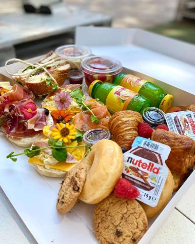 - un plateau de nourriture avec des sandwichs et d'autres aliments dans l'établissement Location exclusive pour les jeux olympiques de Paris et Roland Garros, à Boulogne-Billancourt