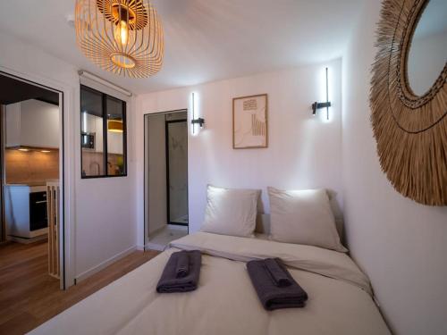 une chambre avec un grand lit avec deux serviettes dessus dans l'établissement Le Perchoir - Appartement 2 pers - Centre Historique, à Aubagne