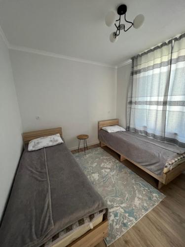a bedroom with two beds and a window at AiDaMaX 2 in Cholpon-Ata