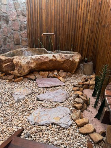 a bathroom with a stone tub and a wooden fence at Vila Cerrado in Alto Paraíso de Goiás