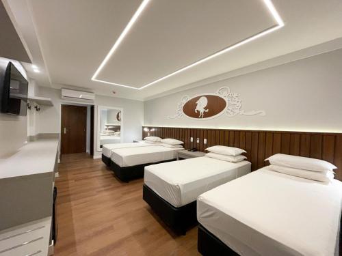 um quarto de hotel com três camas e uma cozinha em Fazzenda Park Resort em Gaspar