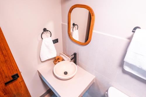 uma casa de banho com um lavatório branco e um espelho. em Bambuda Santa Catalina em Santa Catalina