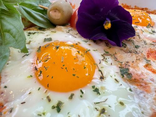 an egg on a plate with a flower on it at Garth Woodside Mansion Bed and Breakfast in Hannibal