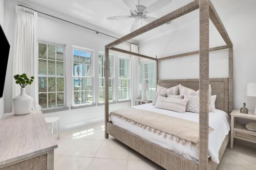 a bedroom with a canopy bed and windows at Devonshire West in Seacrest