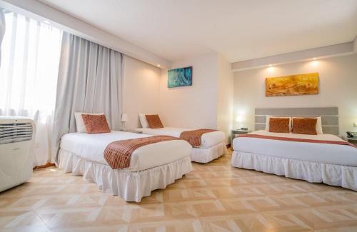 um quarto de hotel com três camas num quarto em HOTEL GAVINA EXPRESS IQUIQUE em Iquique