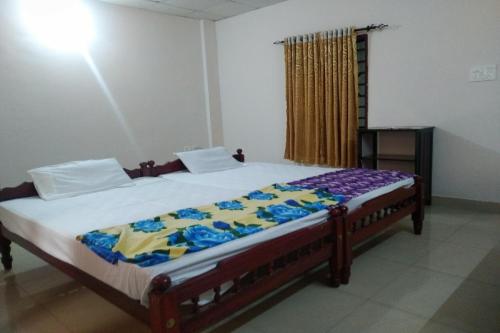 a large bed in a room with a window at SPOT ON Sana Tourist Home in Kollam