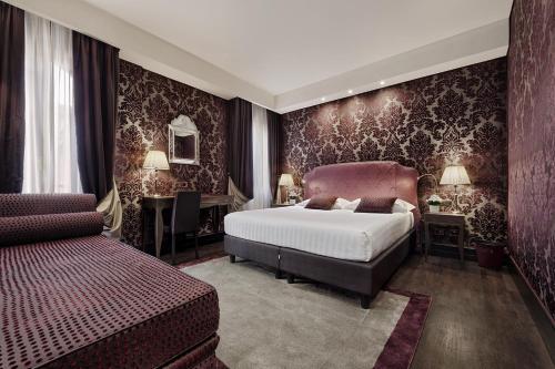 a bedroom with a bed and a desk and a bed sidx sidx sidx at Hotel American-Dinesen in Venice