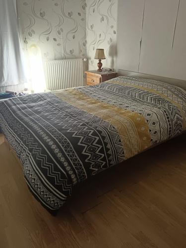 un lit avec une couverture dessus dans une chambre dans l'établissement Appartement proche de Disneyland, à Bussy-Saint-Georges