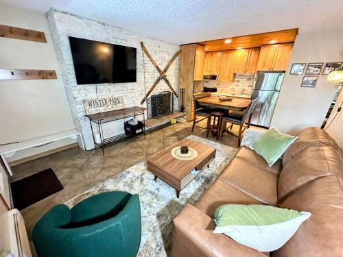 a living room with a couch and a table at Winter Haus, Winter Park 2 bedrooms corner unit w outdoor patio walking distance to the Center of town in Winter Park