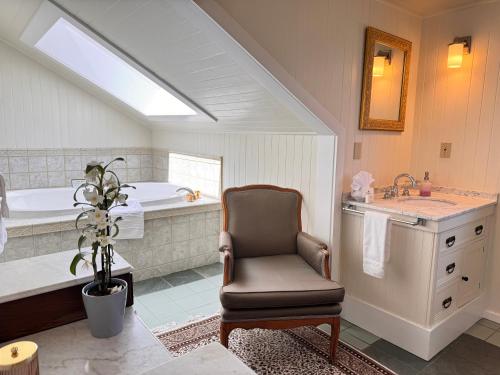 a bathroom with a chair and a bath tub at Prior Castle Inn in Victoria