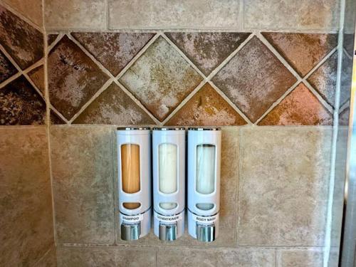 a row of three toothbrushes on a tile wall at Winter Haus, Winter Park 2 bedrooms corner unit w outdoor patio walking distance to the Center of town in Winter Park
