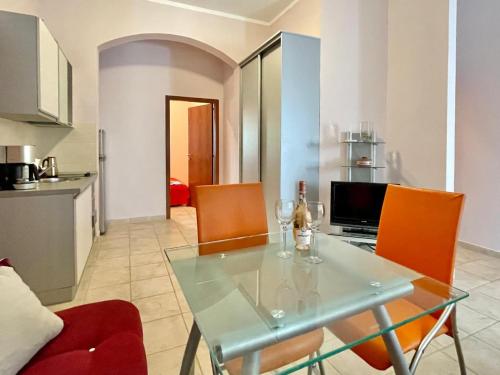 a living room with a glass table and orange chairs at Boris Apartments in Petrovac na Moru