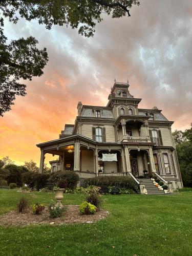 an old house with a sunset in the background at Garth Woodside Mansion Bed and Breakfast in Hannibal