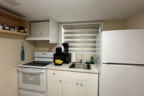 a kitchen with a sink and a white refrigerator at Sabrina's Home in Delta