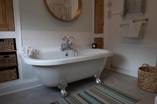 a white bath tub in a bathroom with a mirror at Chester Townhouse in the City Centre in Chester