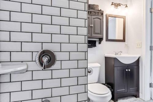 een wit betegelde badkamer met een toilet en een wastafel bij Lake Studio Casita in Akron