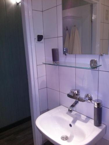 a bathroom with a white sink and a mirror at Apartament Wenecja in Toruń
