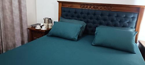1 cama azul con cabecero azul y 2 almohadas en Sweet Home Jaela en Ja-Ela