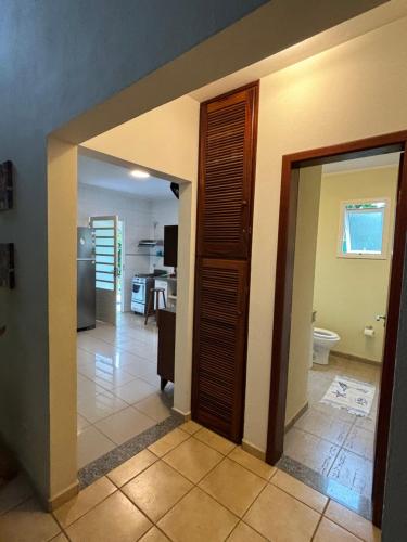 a hallway with a door leading to a kitchen at Praia de Itamambuca- Casa charmosa e iluminada in Ubatuba