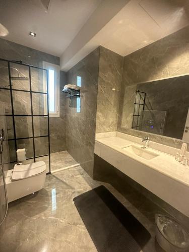 a bathroom with a toilet and a sink and a tub at Jamal Royal Apartments in Medina