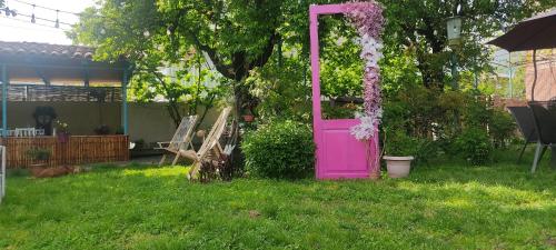 a pink door in the grass in a yard at Lunisi Kvareli in Kvareli