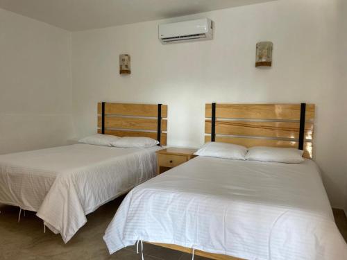 two beds sitting next to each other in a room at Hotel EL Porvenir in Tunas Blancas