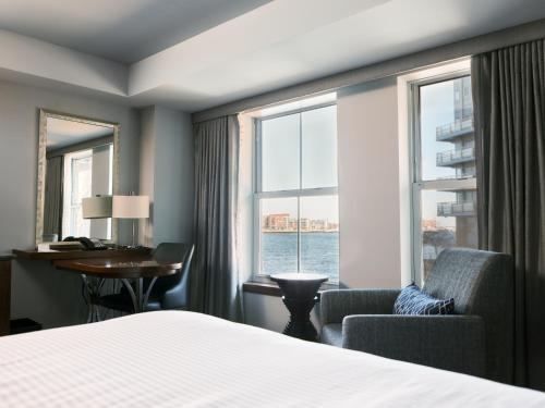 a hotel room with a bed and a desk and a window at Battery Wharf Hotel, Boston Waterfront in Boston