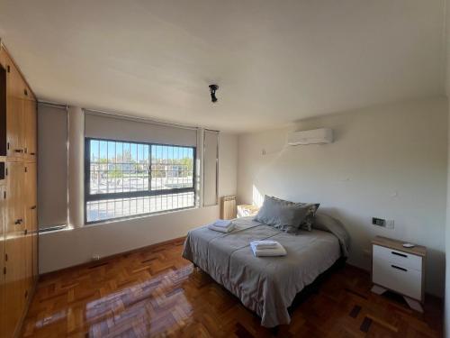 een slaapkamer met een bed en een groot raam bij Casa Nervo in Guaymallen