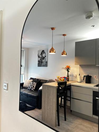 a living room and kitchen with a couch and a table at Stylish Apartment City Centre in Sheffield
