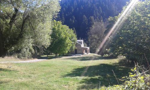 a field with a house in the middle of a forest at Archontiko Nikolopoulou in Vytina