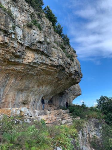 two people walking under a mountain cliff at Casetta Genneria in Seùlo