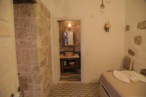 a bedroom with a bed and a stone wall at Filizce Alaçatı in İzmir