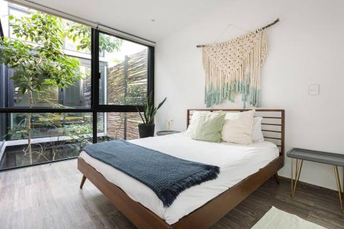 a bedroom with a bed and a large window at Chic Townhouse With Private Pool And Rooftop View in Tulum