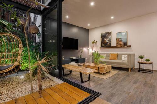 a living room with a couch and a table at Chic Townhouse With Private Pool And Rooftop View in Tulum