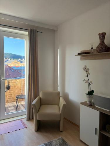 a living room with a chair and a window at Zum Breyer BNB City Apartment in Baden