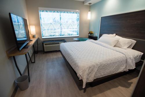 a bedroom with a bed and a flat screen tv at Tru By Hilton Cedar Rapids Westdale in Cedar Rapids