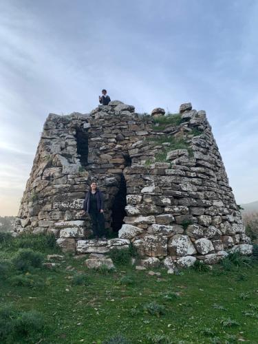 a man sitting on top of an old stone building at Casetta Genneria in Seùlo