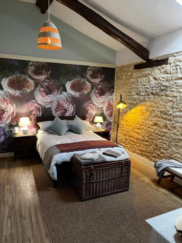 a bedroom with a bed with a flower mural on the wall at Le Vieux Renard in Vieux-Ruffec
