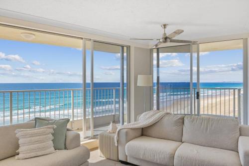 a living room with a couch and views of the ocean at Absolute Beachfront Apartment in Gold Coast