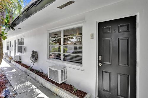 een wit huis met een zwarte deur en een raam bij Victoria Park Regency in Fort Lauderdale
