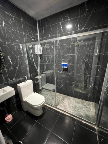 a black tiled bathroom with a toilet and a shower at Red sophia suites in Istanbul
