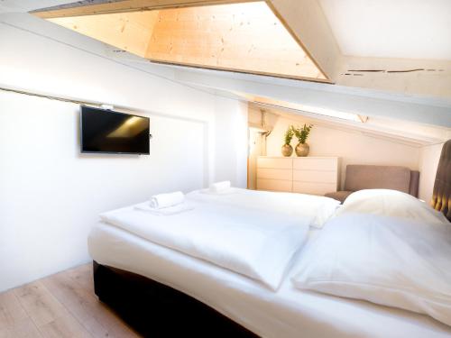 Schlafzimmer mit einem großen weißen Bett und einem Dachfenster in der Unterkunft AlpenLuxus' PANORAMA Appartement with car park and balcony in Mayrhofen