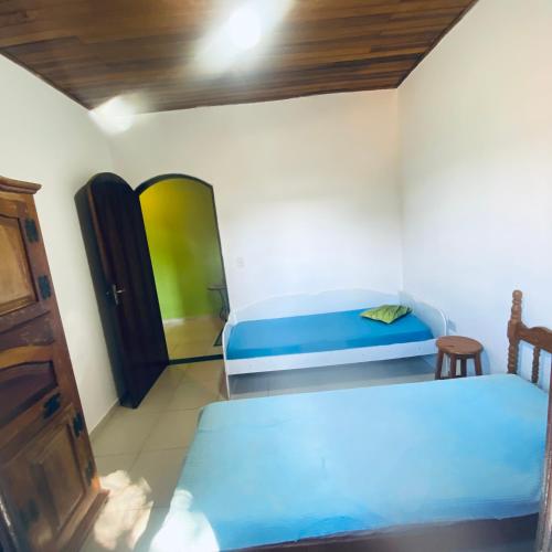 a small room with two beds and a door at Chácara Li&Mazinho in Ibiúna