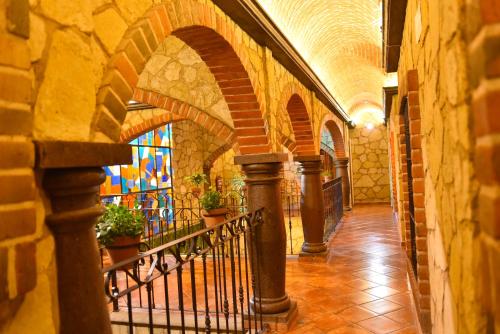 a hallway in an old building with a staircase at Hotel Santa Irene in Cholula