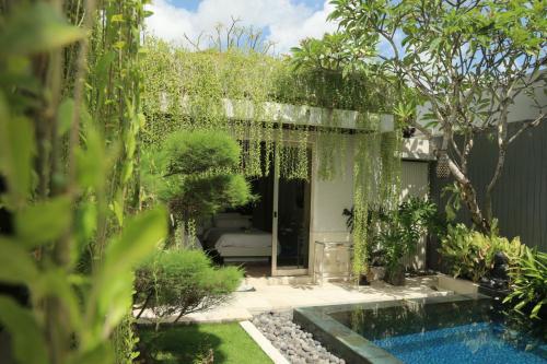 un jardín con piscina y árboles en Vlad Bali Villa, en Jimbaran