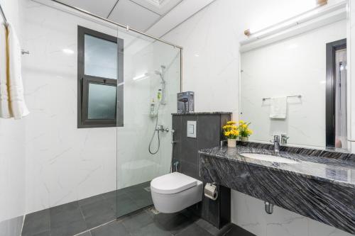 a bathroom with a toilet and a sink and a shower at Luxury Hotel Apartment Mall of Emirates in Dubai