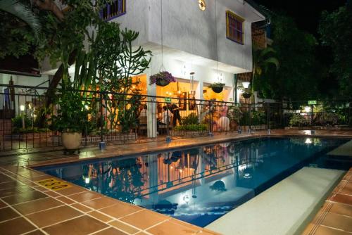 a swimming pool in front of a building at night at Hotel Casa Oliveros in Rivera