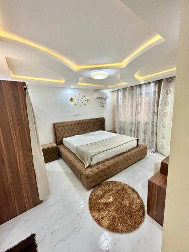 ein Schlafzimmer mit einem großen Bett und einem Teppich in der Unterkunft Soguipis in Conakry
