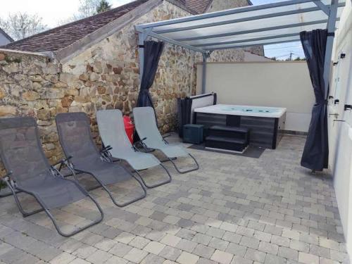 a patio with chairs and a ping pong table at Chambre spacieuse, jacuzzi, proche parc Astérix in Thiers-sur-Thève